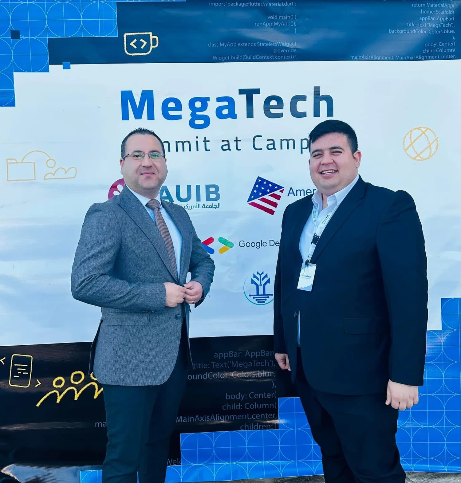 Ali Albodakah with an attendee in front of the MegaTech event backdrop